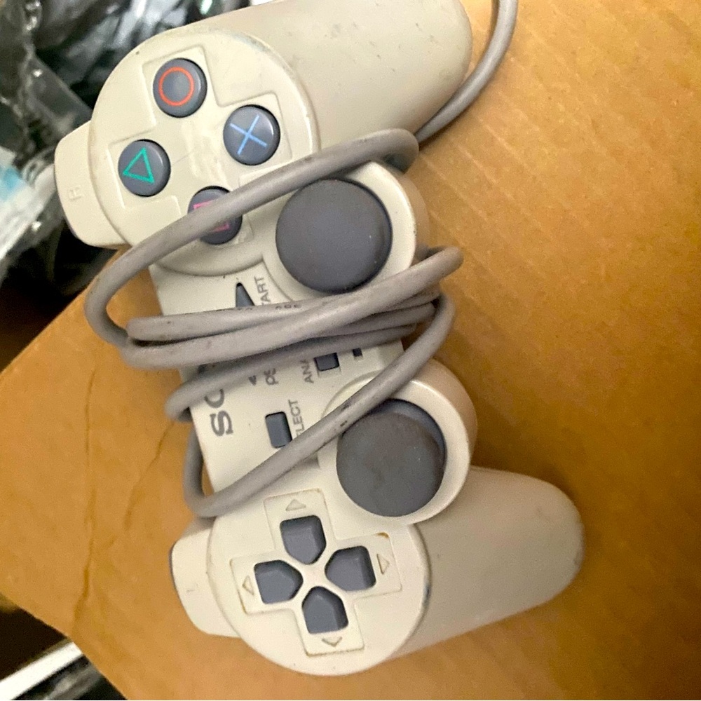 PlayStation 1 counsel with controllers and and game